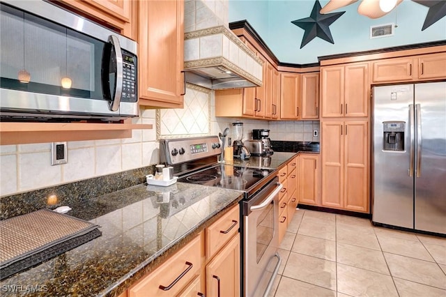 kitchen featuring light tile patterned floors, a ceiling fan, visible vents, appliances with stainless steel finishes, and backsplash