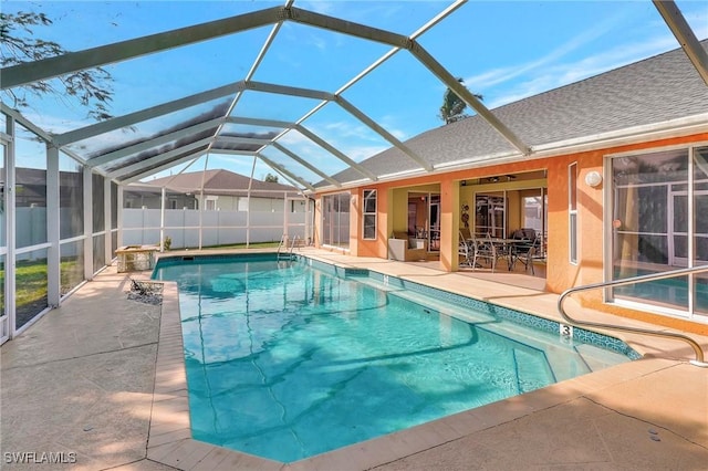 view of pool with glass enclosure, a fenced in pool, a patio area, and fence