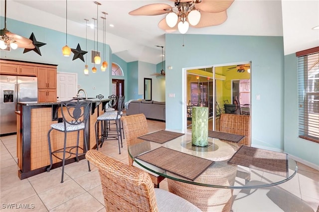 dining room featuring ceiling fan, high vaulted ceiling, and light tile patterned flooring