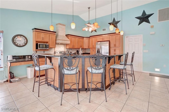 kitchen featuring light tile patterned floors, visible vents, premium range hood, stainless steel appliances, and dark countertops