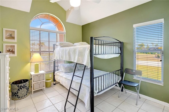 tiled bedroom with baseboards, a ceiling fan, and vaulted ceiling