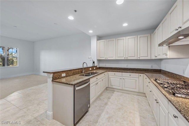 kitchen with sink, white cabinetry, dark stone countertops, appliances with stainless steel finishes, and kitchen peninsula