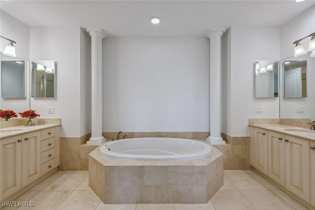 bathroom featuring a relaxing tiled tub, vanity, tile patterned flooring, and decorative columns