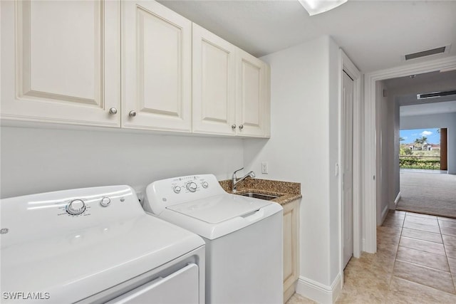 clothes washing area featuring cabinets, washer and clothes dryer, sink, and light tile patterned floors