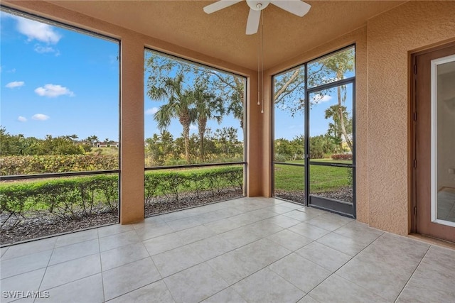 unfurnished sunroom with ceiling fan