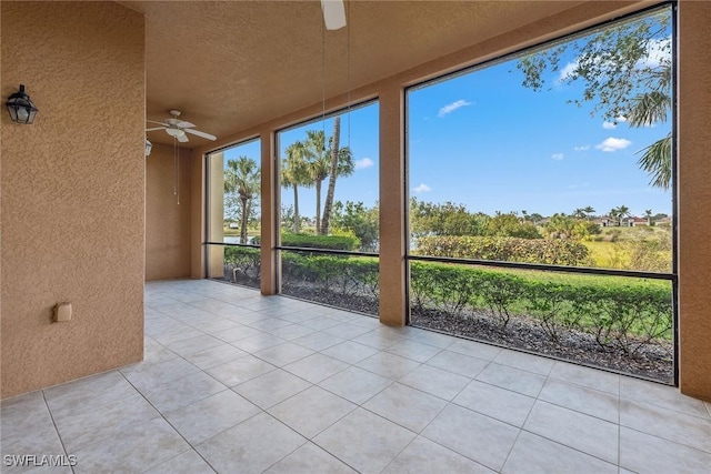 unfurnished sunroom with ceiling fan