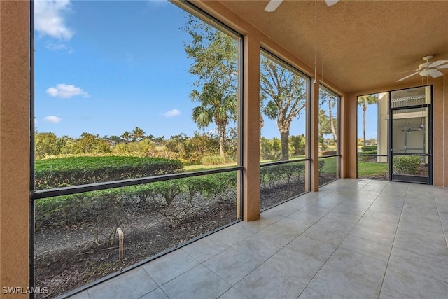 unfurnished sunroom with ceiling fan