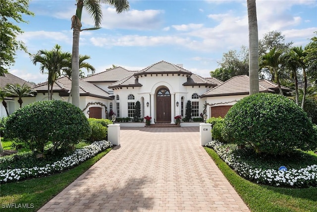 mediterranean / spanish home featuring a garage