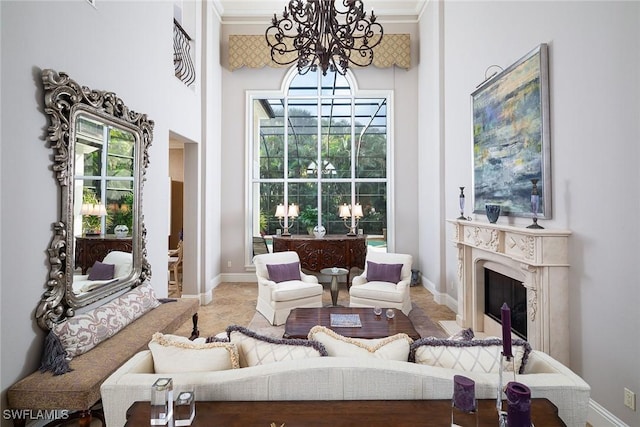 sitting room featuring a healthy amount of sunlight, crown molding, a notable chandelier, and a fireplace