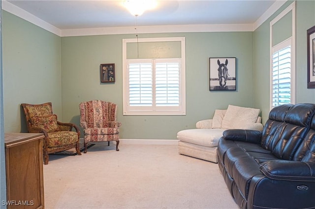 sitting room with ornamental molding, a healthy amount of sunlight, and carpet