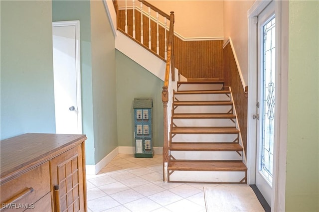 staircase with plenty of natural light and tile patterned floors