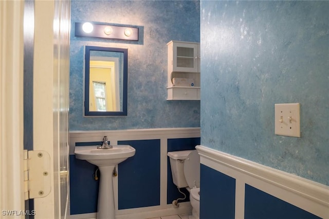 bathroom with sink, toilet, and tile patterned flooring