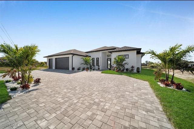 view of front of property featuring a garage and a front lawn