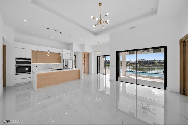 kitchen with stainless steel appliances, pendant lighting, and a notable chandelier