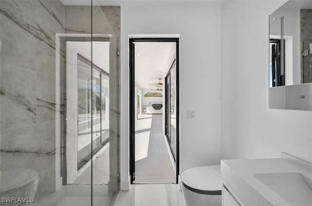 bathroom featuring vanity, toilet, and a shower with shower door