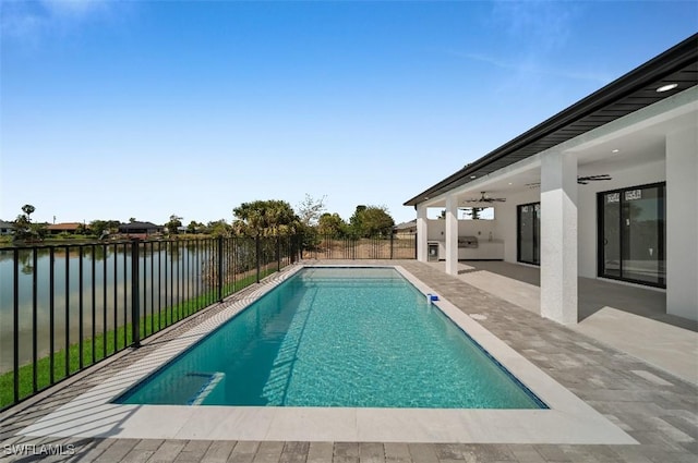 view of swimming pool with a water view, ceiling fan, and a patio