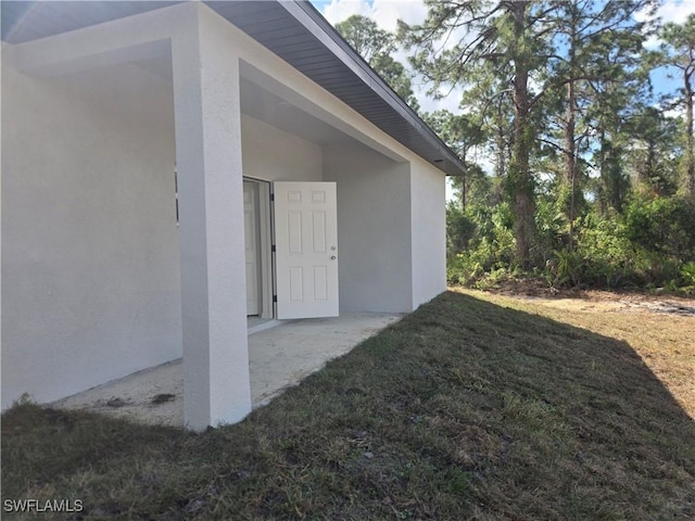 exterior space with a yard and stucco siding