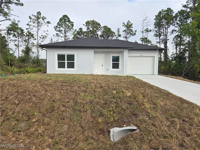 view of front of home with driveway, a front lawn, an attached garage, and stucco siding