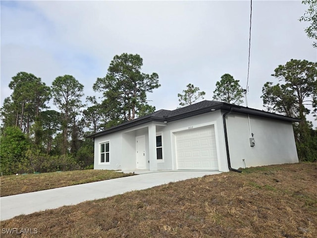 view of front of property featuring concrete driveway, a front lawn, an attached garage, and stucco siding