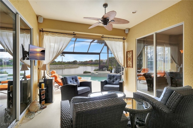 sunroom with plenty of natural light, ceiling fan, and a water view