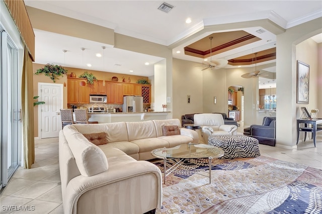 living room featuring ornamental molding, light tile patterned flooring, and a tray ceiling