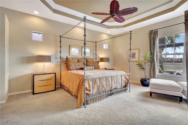 carpeted bedroom featuring crown molding and a tray ceiling