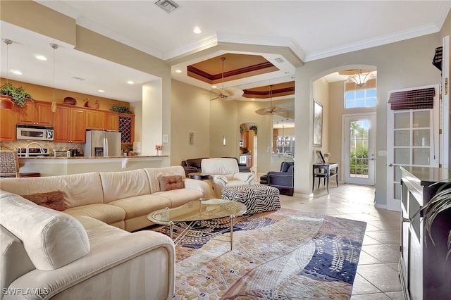 tiled living room featuring ornamental molding and a towering ceiling