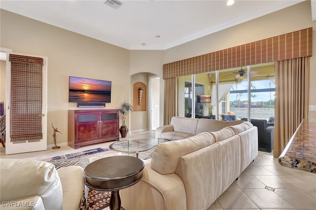 living room with light tile patterned floors, crown molding, and ceiling fan