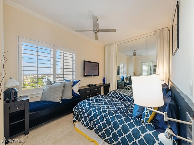 bedroom featuring ornamental molding, ceiling fan, and a closet