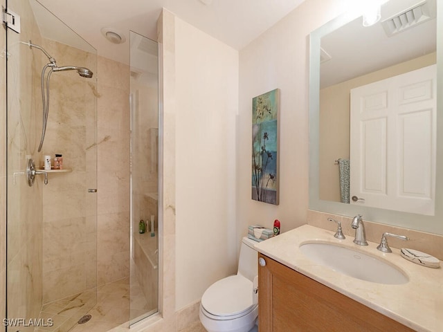 bathroom featuring vanity, toilet, and a shower with shower door