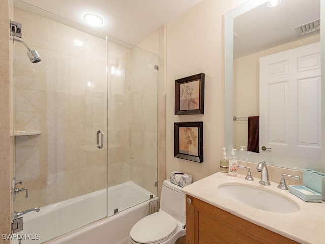 full bathroom featuring vanity, enclosed tub / shower combo, and toilet