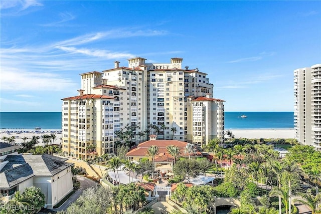 view of building exterior with a water view and a view of the beach