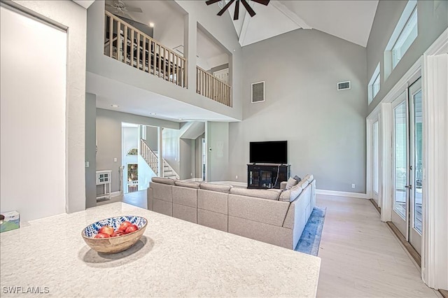 living room with high vaulted ceiling, light hardwood / wood-style floors, and ceiling fan