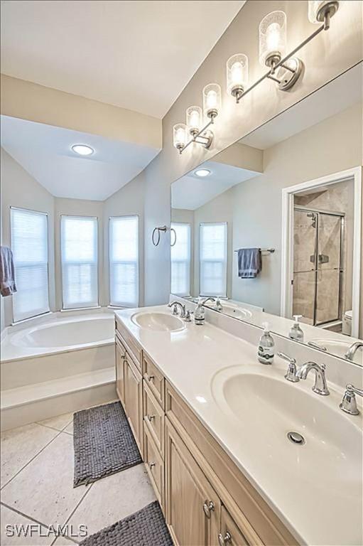 full bathroom featuring tile patterned floors, toilet, independent shower and bath, and vanity