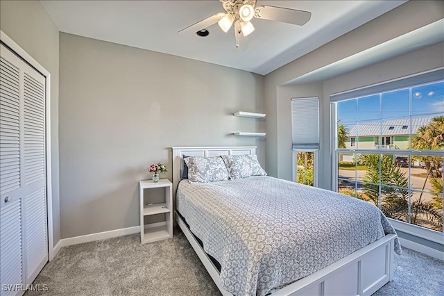 carpeted bedroom featuring ceiling fan and a closet