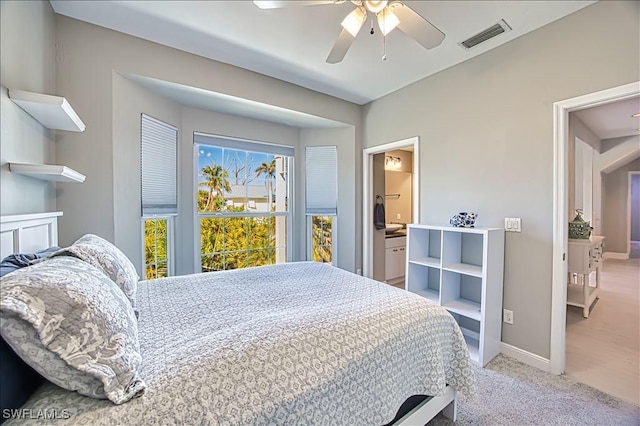 carpeted bedroom featuring ensuite bath and ceiling fan