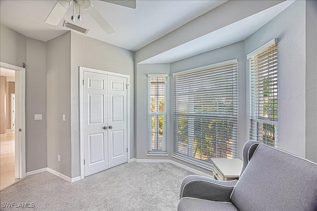 sitting room with light colored carpet and ceiling fan