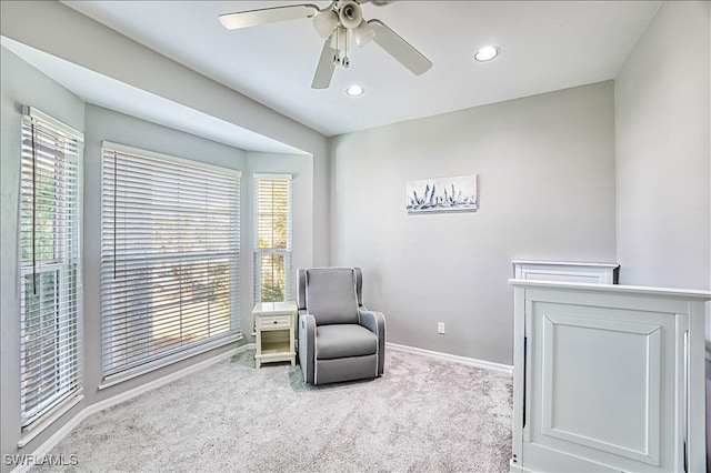 sitting room with light colored carpet and ceiling fan