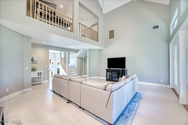 living room featuring light hardwood / wood-style floors and a high ceiling