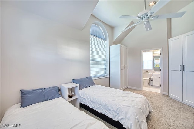 carpeted bedroom featuring ceiling fan and ensuite bathroom