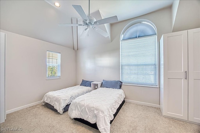 bedroom with vaulted ceiling, light colored carpet, and ceiling fan