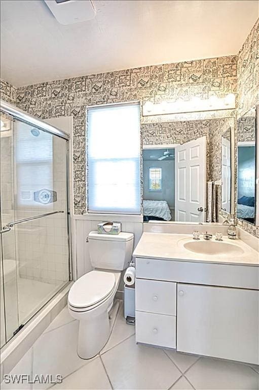 bathroom with vanity, walk in shower, tile patterned floors, and toilet