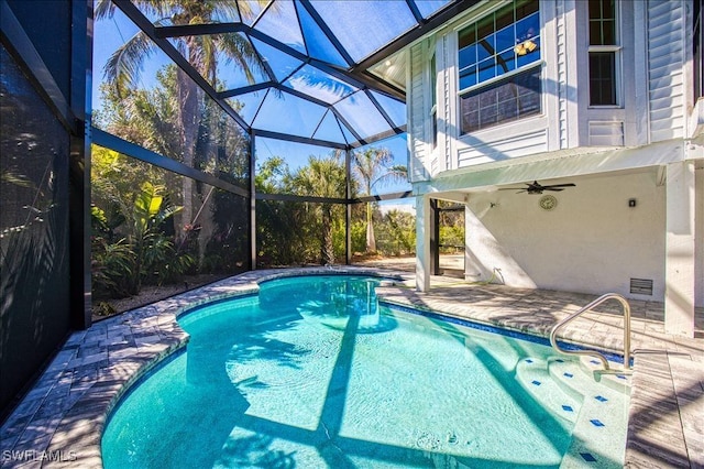 view of pool featuring ceiling fan, glass enclosure, and a patio area