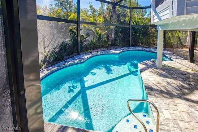 view of pool featuring glass enclosure and a patio area