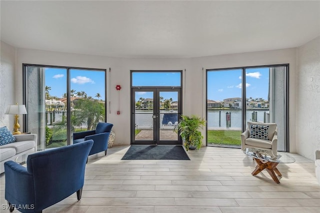 interior space featuring light hardwood / wood-style flooring, plenty of natural light, and a water view