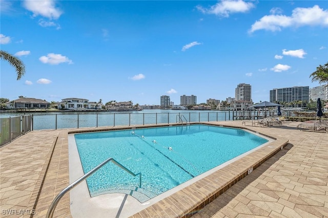 view of swimming pool with a water view and a patio