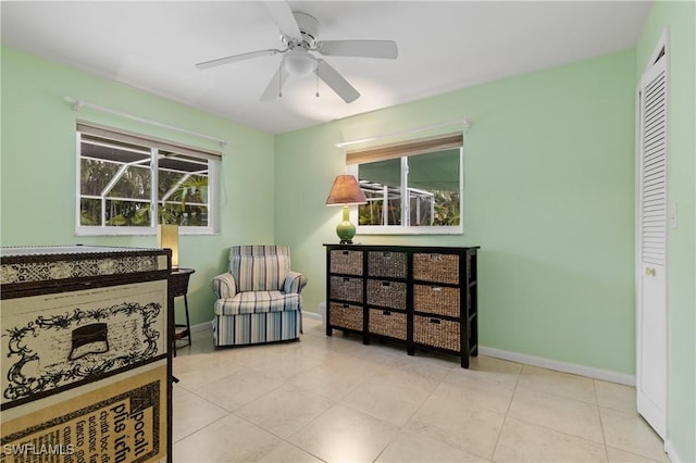 living area featuring light tile patterned floors and ceiling fan