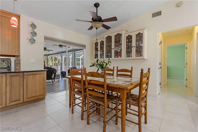 tiled dining area featuring vaulted ceiling and ceiling fan