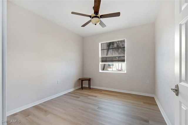 spare room with light wood finished floors, baseboards, and ceiling fan