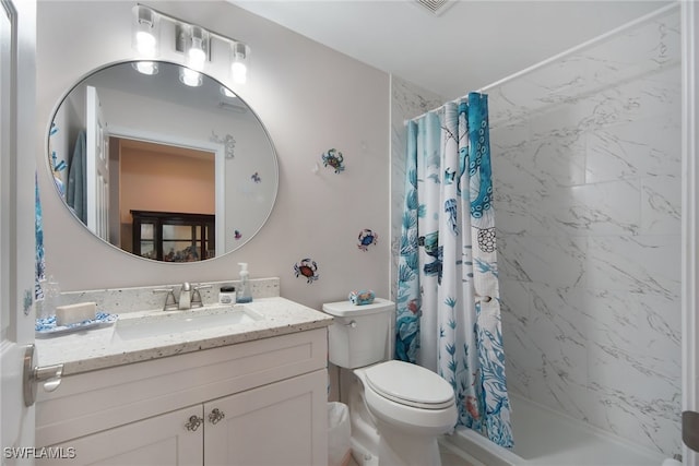 bathroom with a shower stall, toilet, and vanity